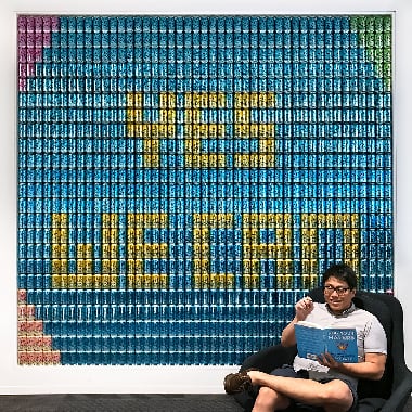 一名男子在罐子壁画下阅读社交媒体，上面写着YES WE爱游戏官网皇 can