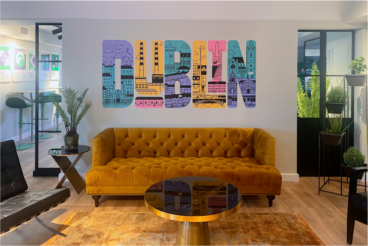 金色的簇绒沙发和带镜子的咖啡桌，前面是一幅彩色的都柏林壁画。