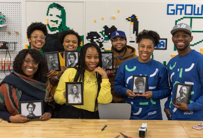 黑人在斯普劳特商业资源小组的成员自豪地拿着历史上爱游戏体育官网首页有影响力的黑人领袖的照片。